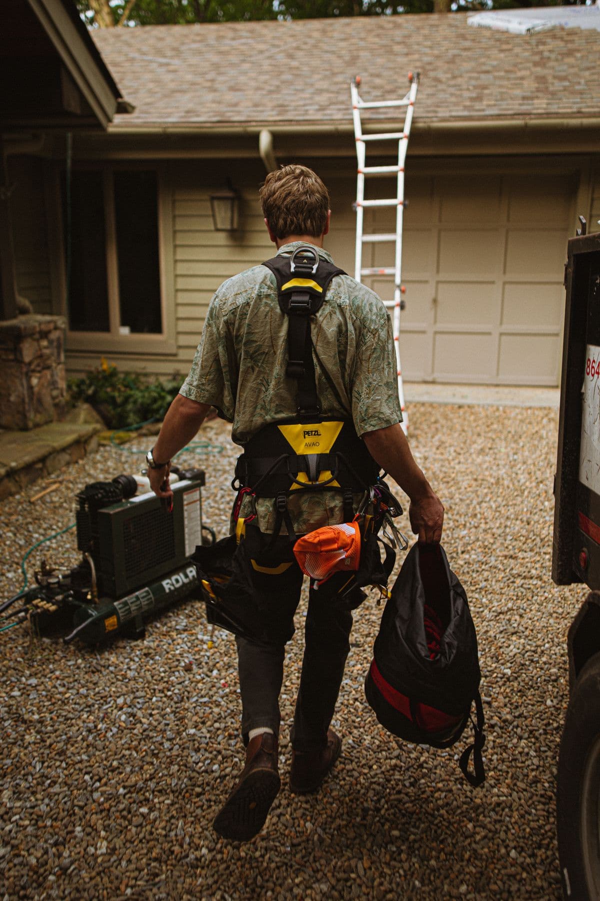 Roofer carrying tools to a residential job site